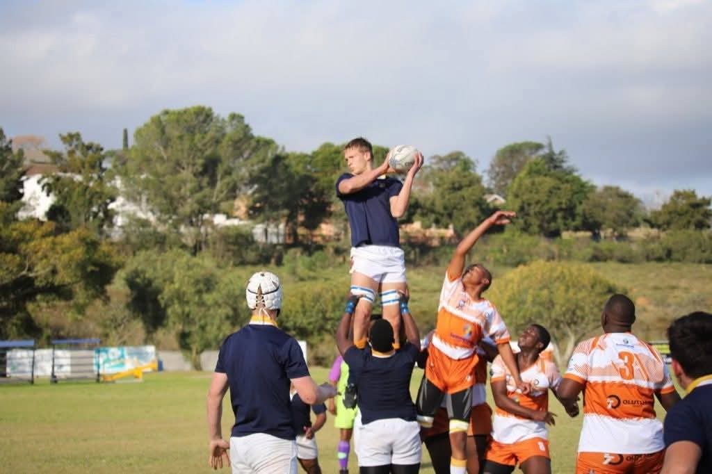 Olutsha players in orange contesting a lineout against a navy-jerseyed side
